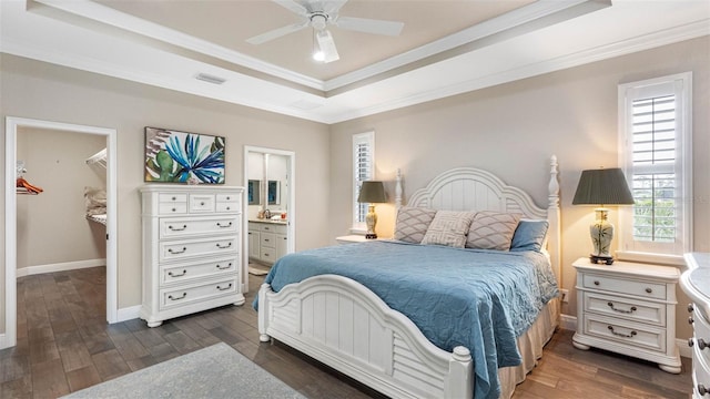 135 Cabana Way, Rotonda West, FL 33947 - bedroom featuring a tray ceiling, dark wood finished floors, crown molding, a spacious closet, and baseboards