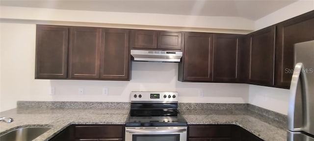 kitchen with under cabinet range hood, light stone counters, a sink, stainless steel appliances, and dark brown cabinetry