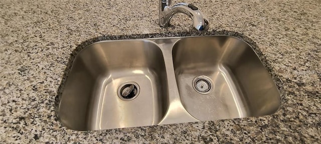 details with dark stone countertops and a sink