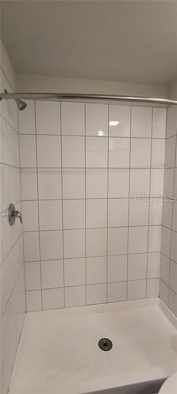 bathroom with a shower stall and toilet