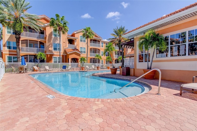 pool with a patio and fence