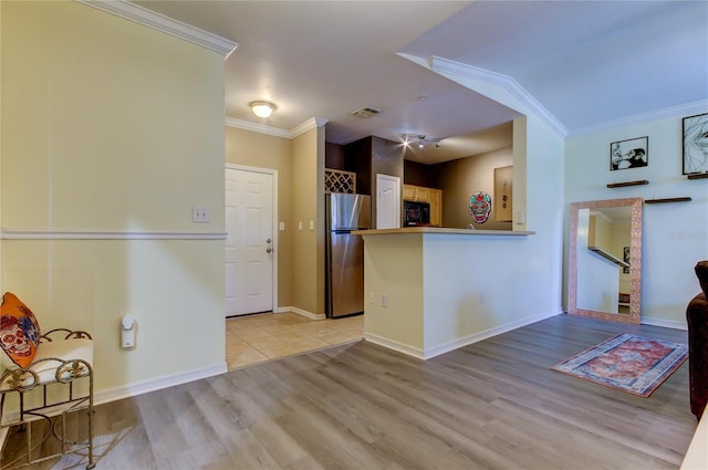 kitchen featuring visible vents, ornamental molding, freestanding refrigerator, light wood-type flooring, and black microwave