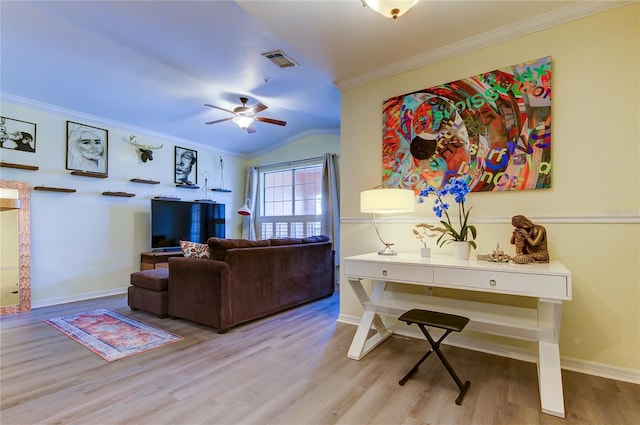 living room featuring ceiling fan, ornamental molding, light wood-type flooring, and visible vents