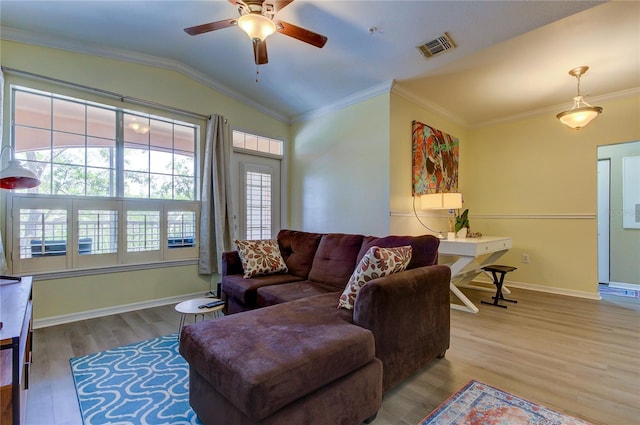 living room featuring lofted ceiling, wood finished floors, visible vents, baseboards, and ornamental molding