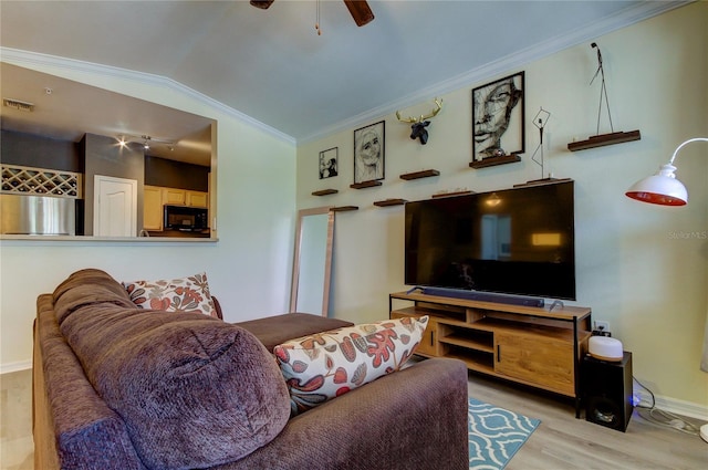 living area featuring lofted ceiling, wood finished floors, a ceiling fan, visible vents, and crown molding