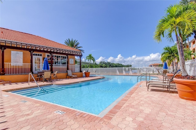 community pool featuring fence and a patio