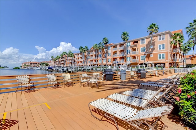 deck with a water view and a grill