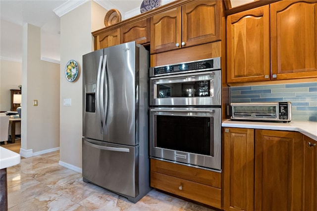 kitchen with stainless steel appliances, brown cabinetry, light countertops, and backsplash