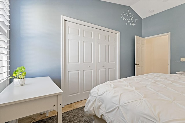 bedroom with lofted ceiling and a closet