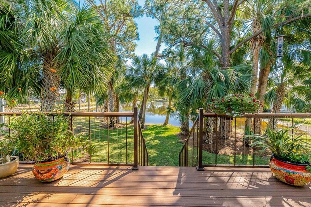 wooden deck with a yard and a water view