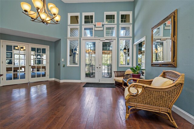 entrance foyer with french doors, baseboards, wood-type flooring, and a high ceiling