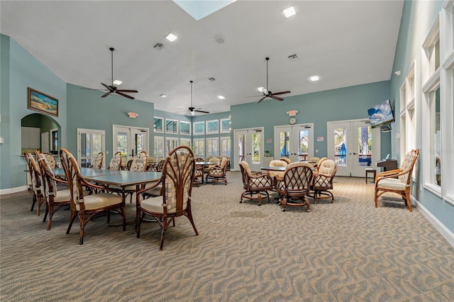 carpeted dining room featuring french doors, a towering ceiling, visible vents, and baseboards