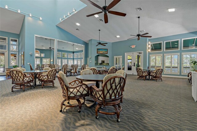 carpeted dining room with high vaulted ceiling, french doors, and visible vents