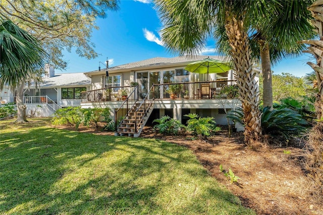 back of house with a lawn, a wooden deck, and stairs