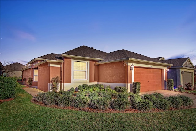 view of front of house featuring a garage, driveway, a front lawn, and stucco siding