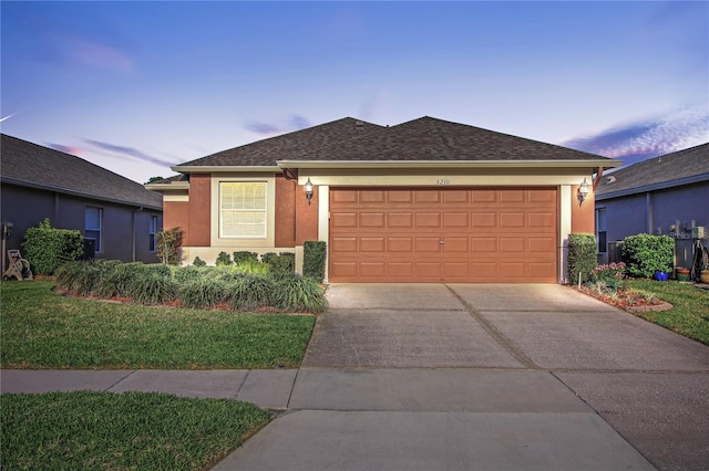 single story home with a garage, a front yard, concrete driveway, and stucco siding