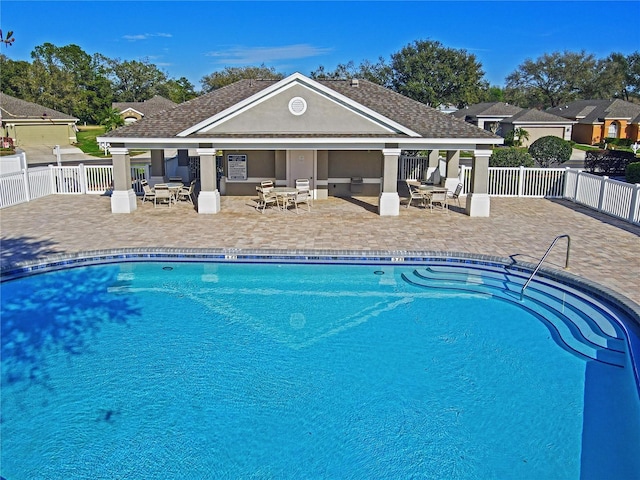 community pool featuring a patio and fence