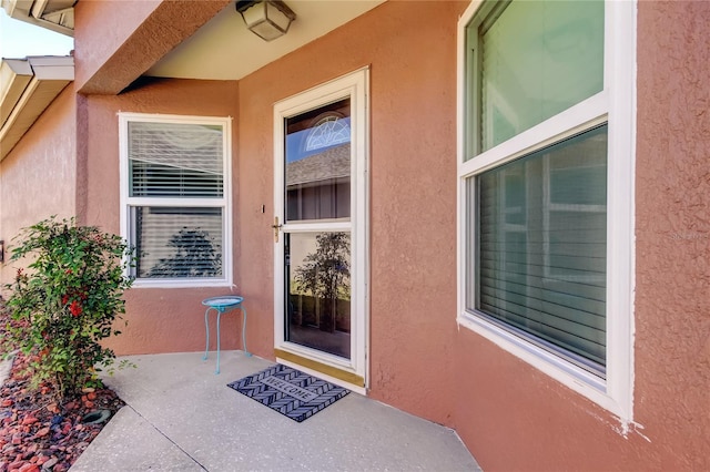 entrance to property featuring stucco siding