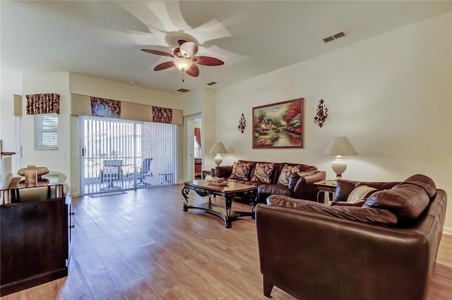 living area with light wood-type flooring, visible vents, and a ceiling fan