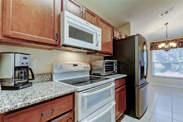 kitchen with light tile patterned flooring, a toaster, white appliances, visible vents, and an inviting chandelier