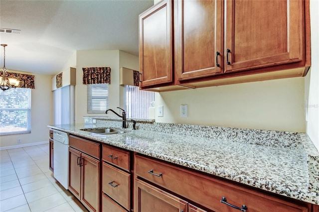 kitchen featuring dishwasher, brown cabinetry, a sink, and visible vents