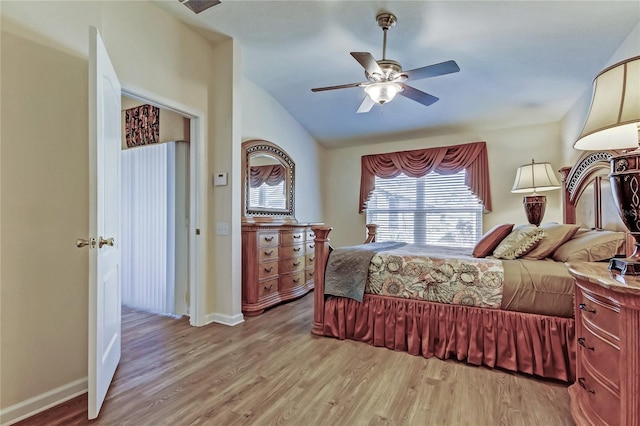 bedroom with lofted ceiling, light wood finished floors, a ceiling fan, and baseboards