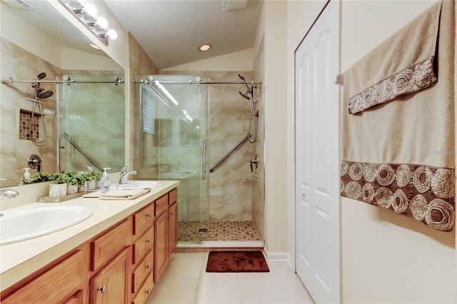 bathroom featuring double vanity, a stall shower, and a sink