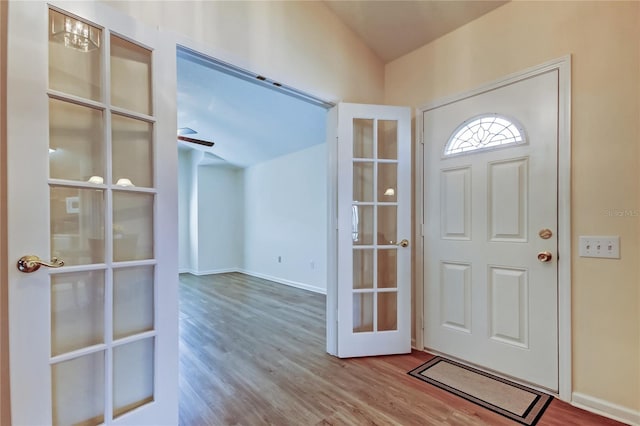 foyer with a ceiling fan, baseboards, and wood finished floors