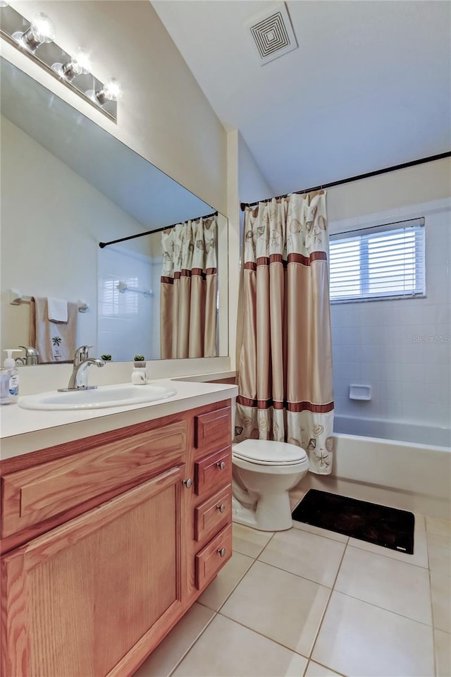 bathroom featuring lofted ceiling, visible vents, toilet, vanity, and tile patterned flooring