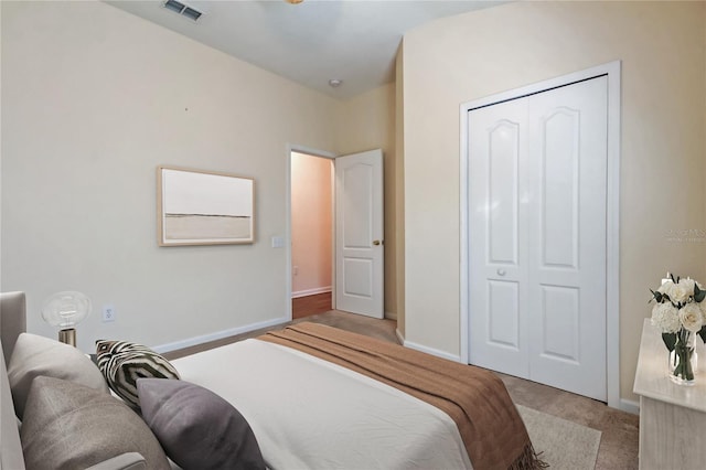 bedroom featuring carpet floors, baseboards, visible vents, and a closet