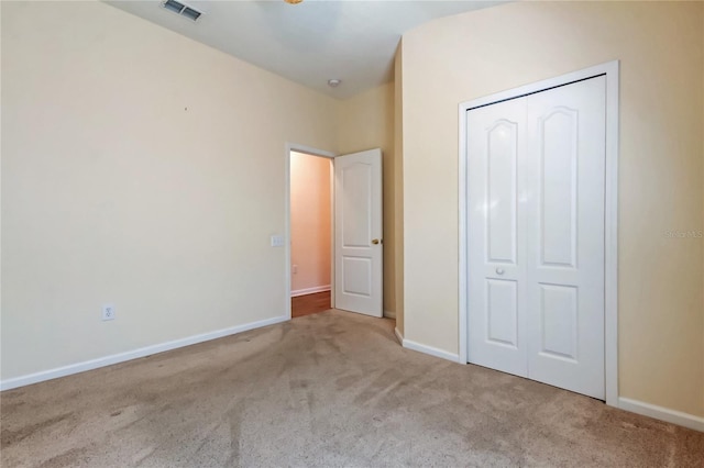 unfurnished bedroom with carpet floors, a closet, visible vents, and baseboards