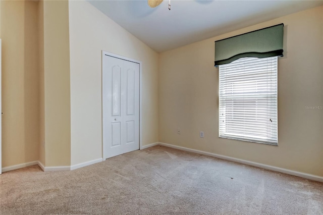 unfurnished bedroom featuring carpet floors, baseboards, and vaulted ceiling