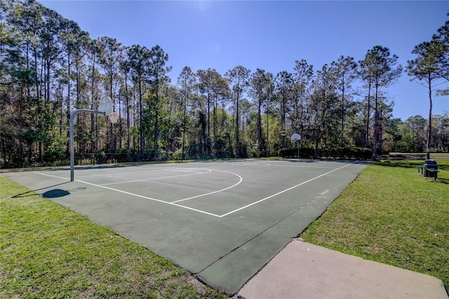 view of basketball court with community basketball court and a lawn