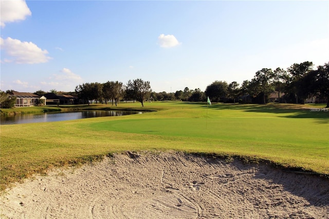 view of property's community with a water view, golf course view, and a lawn