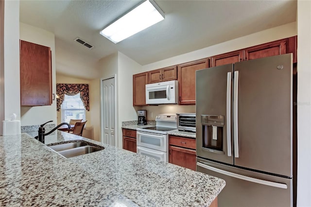 kitchen with white appliances, a toaster, visible vents, light stone countertops, and a sink