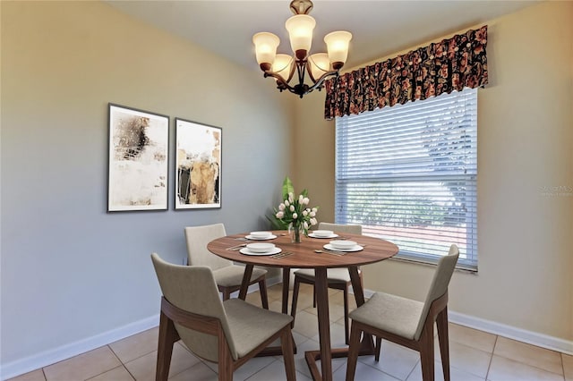 dining area featuring an inviting chandelier, light tile patterned floors, and baseboards