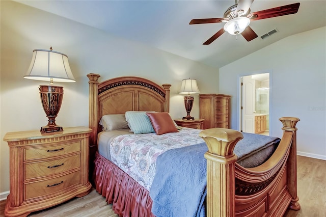 bedroom featuring lofted ceiling, visible vents, light wood-style flooring, a ceiling fan, and connected bathroom