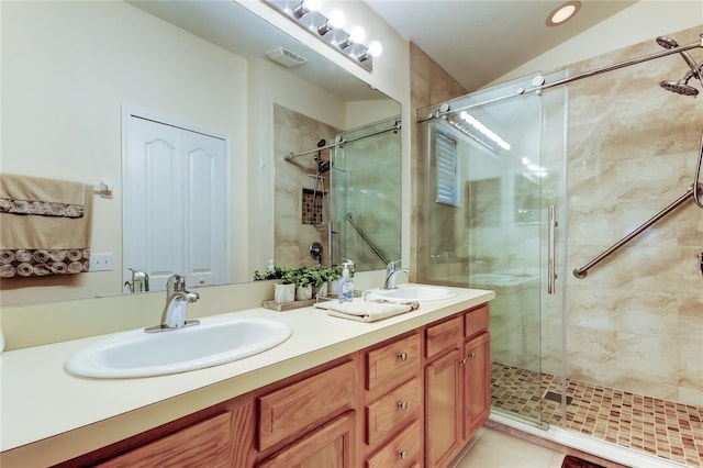 full bath with a sink, a shower stall, and double vanity