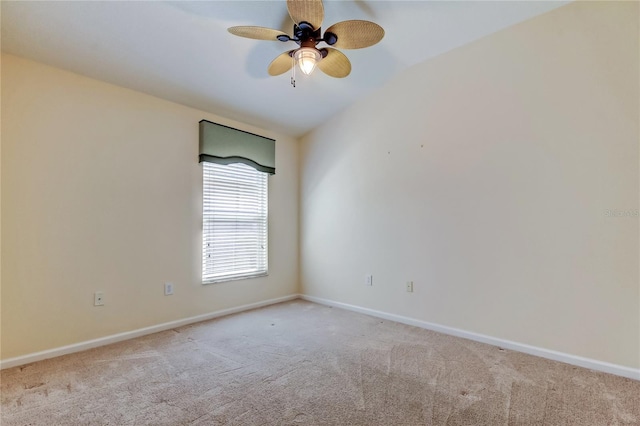 carpeted empty room featuring baseboards, vaulted ceiling, and a ceiling fan