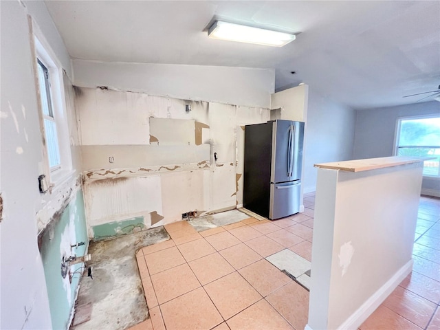 kitchen featuring freestanding refrigerator, light tile patterned flooring, vaulted ceiling, and ceiling fan