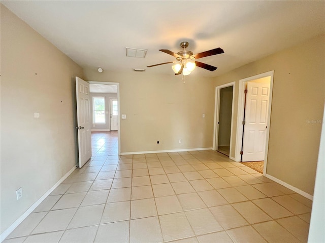 spare room with light tile patterned floors, ceiling fan, and baseboards