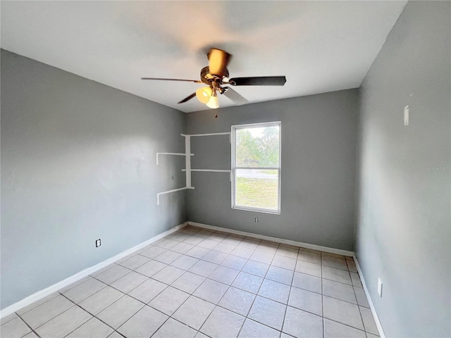 unfurnished room with light tile patterned floors, ceiling fan, and baseboards