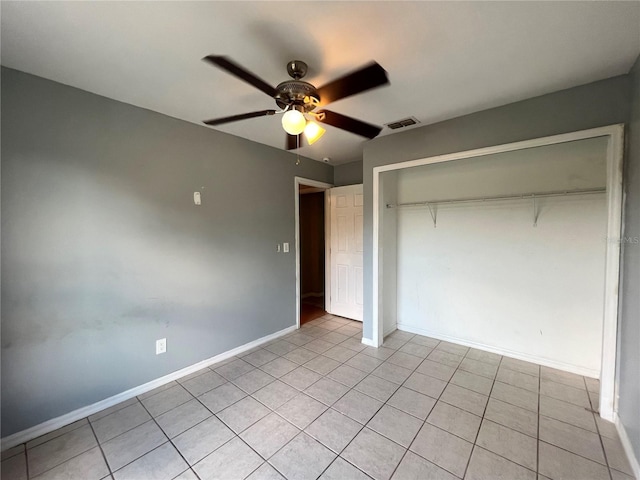 unfurnished bedroom with light tile patterned floors, baseboards, visible vents, a ceiling fan, and a closet