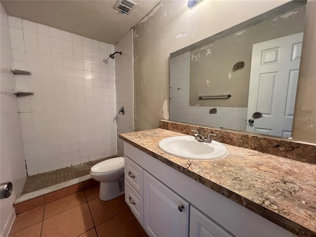 bathroom with visible vents, tiled shower, toilet, tile patterned flooring, and vanity