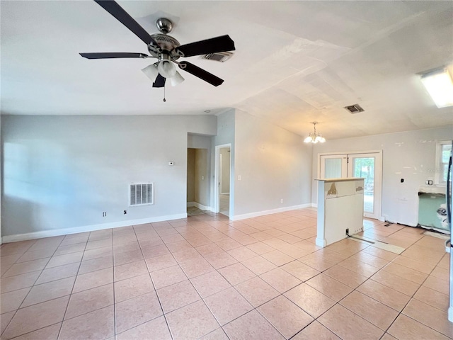 empty room featuring light tile patterned floors, visible vents, and vaulted ceiling