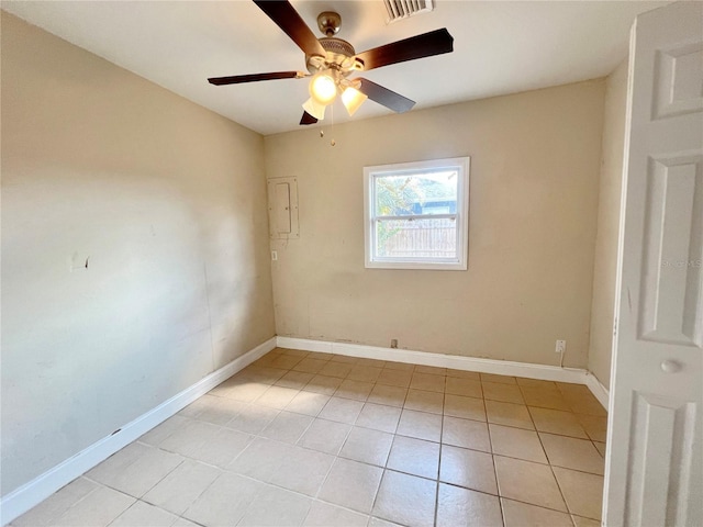 empty room with light tile patterned flooring, ceiling fan, visible vents, and baseboards