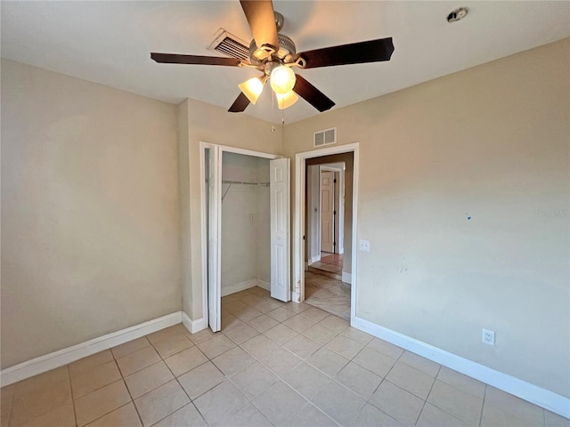 unfurnished bedroom featuring light tile patterned floors, baseboards, visible vents, ceiling fan, and a closet