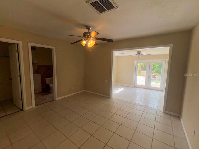 empty room with light tile patterned floors, french doors, visible vents, and baseboards