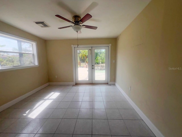 unfurnished room featuring a healthy amount of sunlight, visible vents, french doors, and tile patterned floors