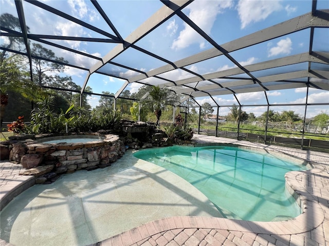 view of swimming pool featuring a lanai, a patio area, and a pool with connected hot tub